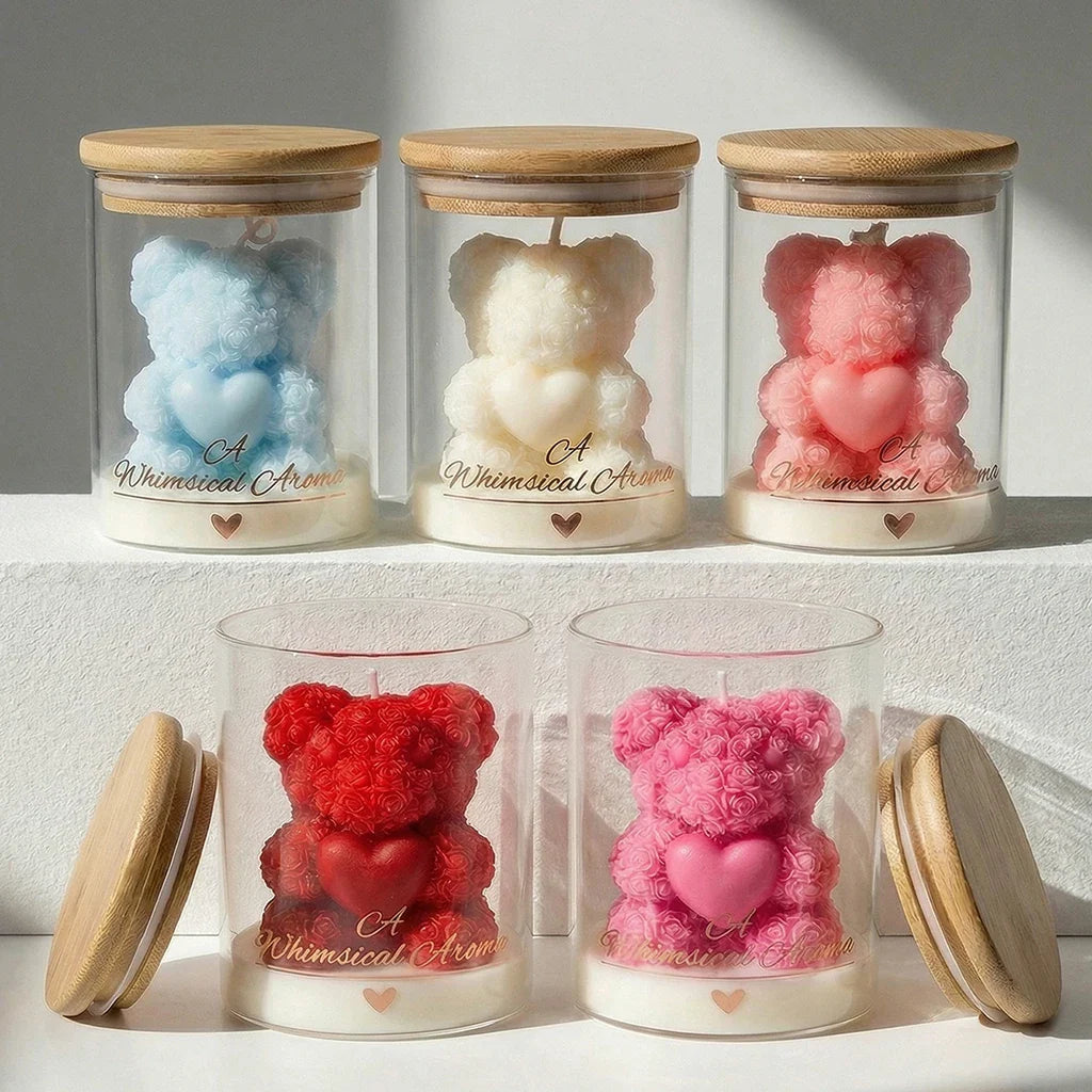Set of five glass jars with wooden lids, each containing a teddy bear-shaped candle in different colors.