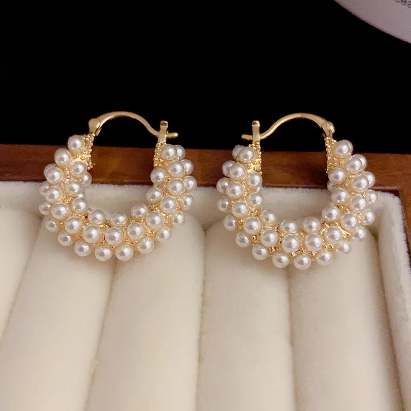 Chic pearl earrings with oversized hoops, adding sophistication to any outfit.