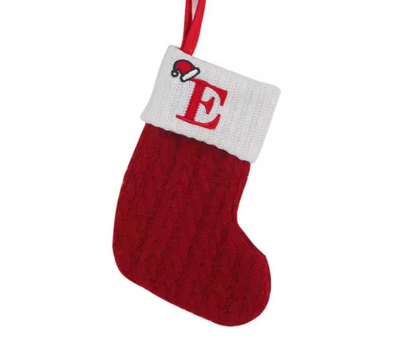 Red knitted Christmas stocking with white cuff featuring the letter 'E' on a white background