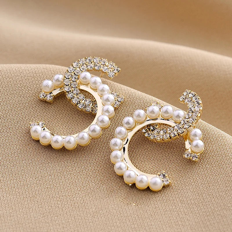 Elegant initial shaped earrings featuring pearls and rhinestones for a personalized touch.