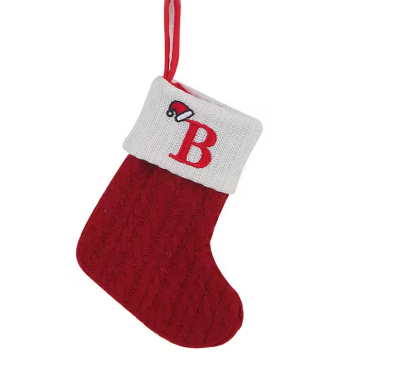 Red knitted Christmas stocking with a white cuff featuring a red letter 'B' on a white background.