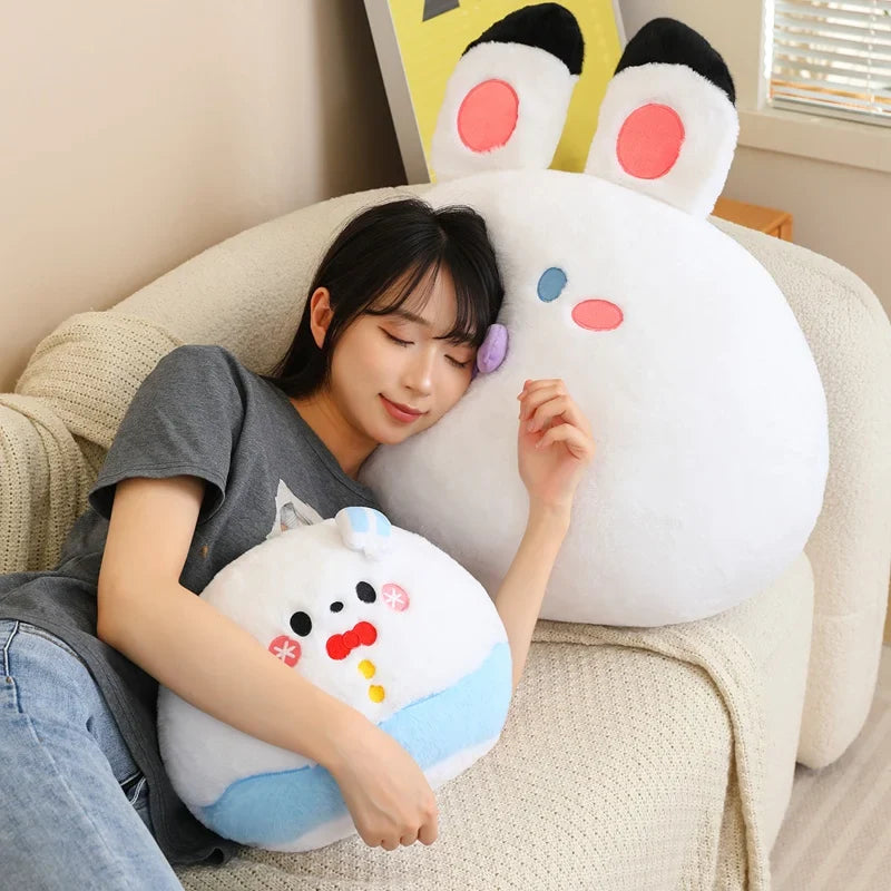 Person holding a large, cute plush toy with animal ears on a couch.