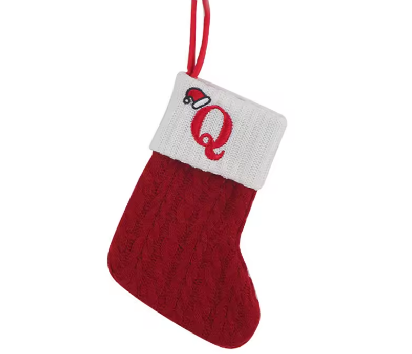 Red knitted Christmas stocking with a white cuff featuring a red letter 'Q' on a white background.