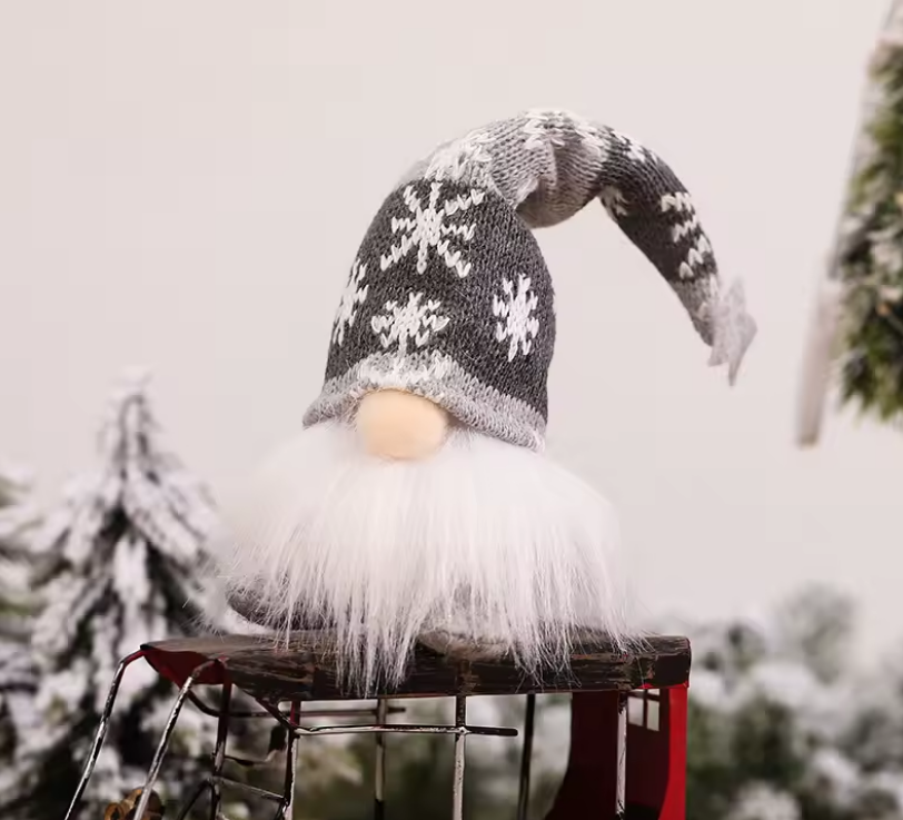 Decorative gnome with a snowflake-patterned hat against a snowy background