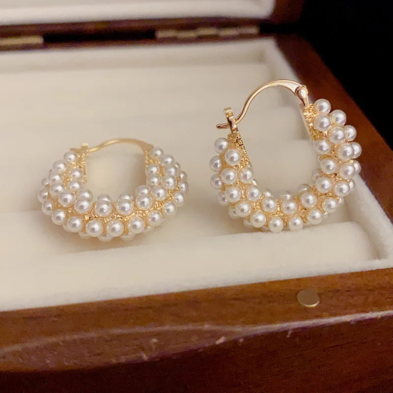 Luxury women's earrings featuring big round hoops and lustrous pearls.
