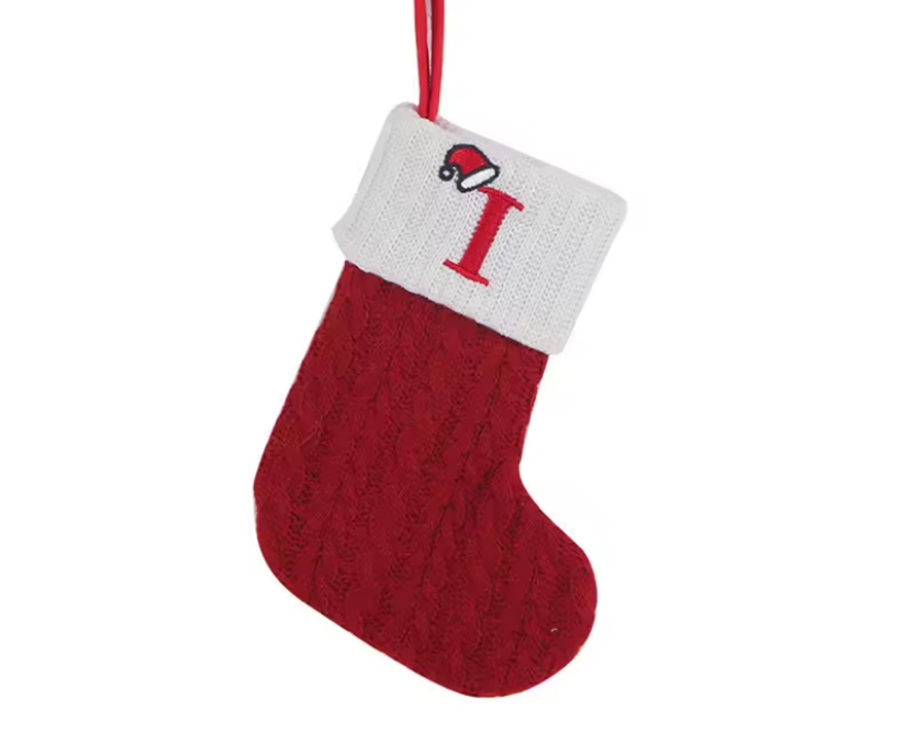 Red Christmas stocking with white cuff featuring a letter 'I' on a white background