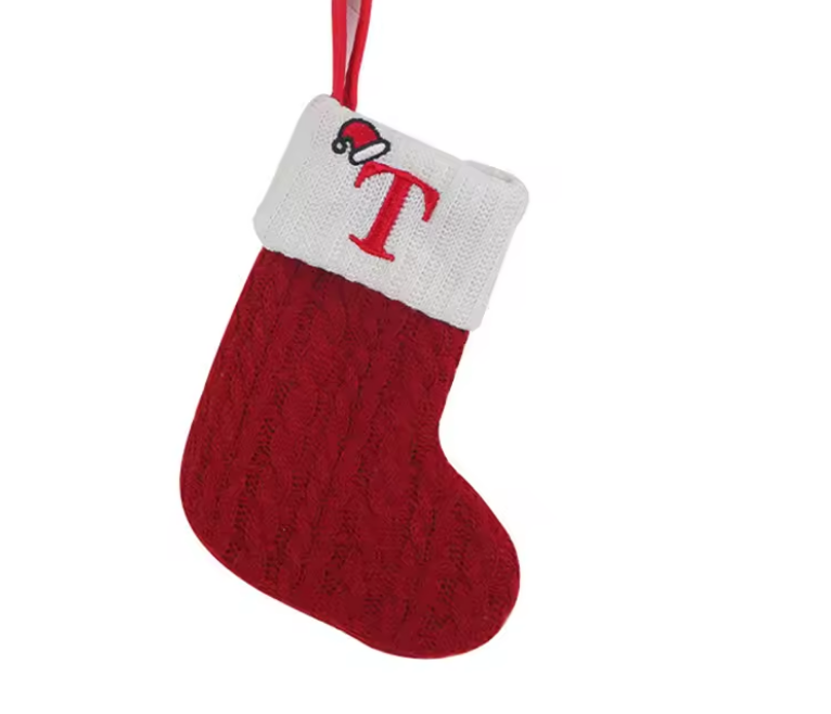 Red knitted Christmas stocking with white cuff featuring a red letter 'T' on a white background