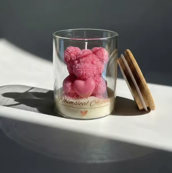 Pink teddy bear and heart in a clear glass jar with 'Whimsical Adventures' label on a white surface.