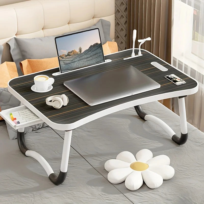 Compact foldable laptop desk with a USB-powered light and slot for tablet or phone.