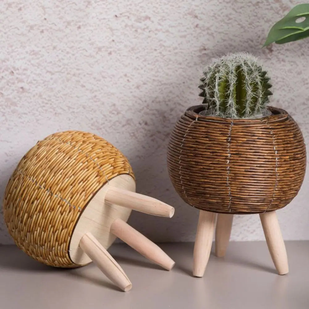 Rattan woven flower pot with wooden legs on table