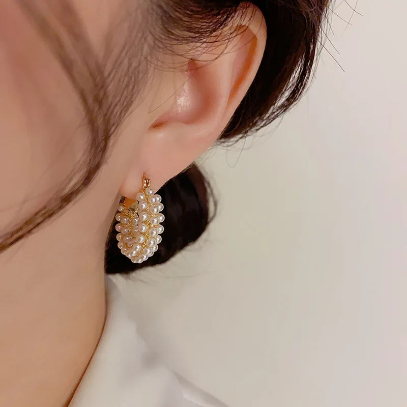 Modern and bold pearl hoop earrings with a large round shape for a statement look.