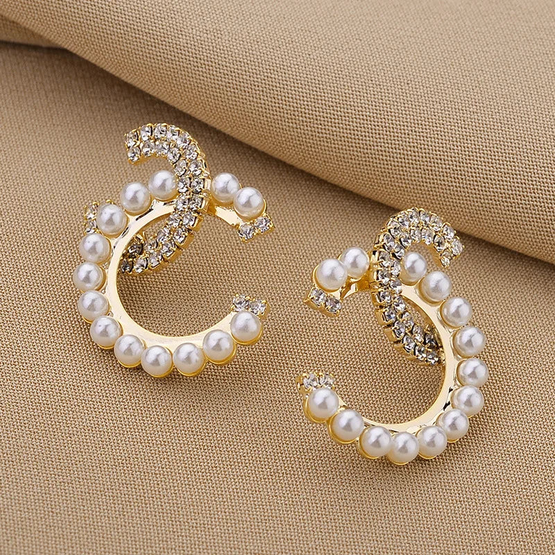 Stylish letter shaped earrings with delicate pearl inlays and sparkling rhinestones.