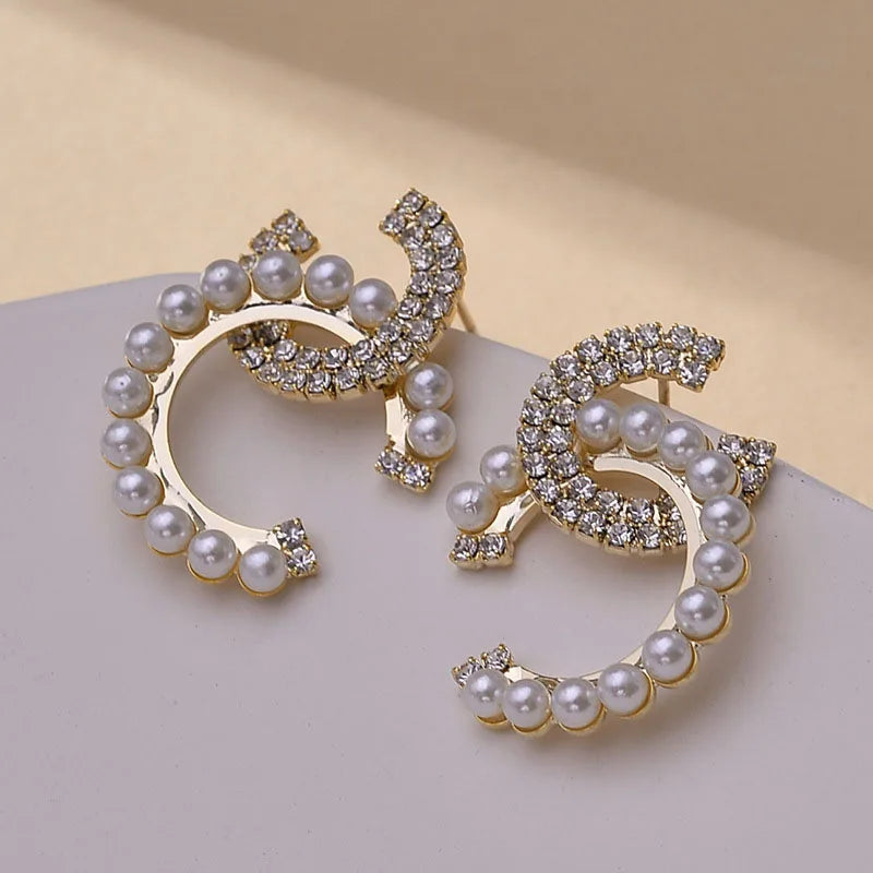 Delicate initial earrings with pearl and rhinestone accents for a luxurious finish.