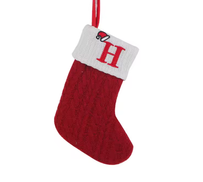 Red knitted Christmas stocking with a white cuff featuring a red letter 'H' on a white background.