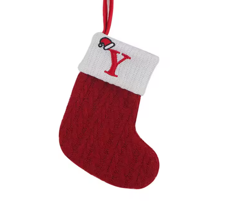 Red knitted Christmas stocking with white cuff displaying the letter 'Y' on a white background