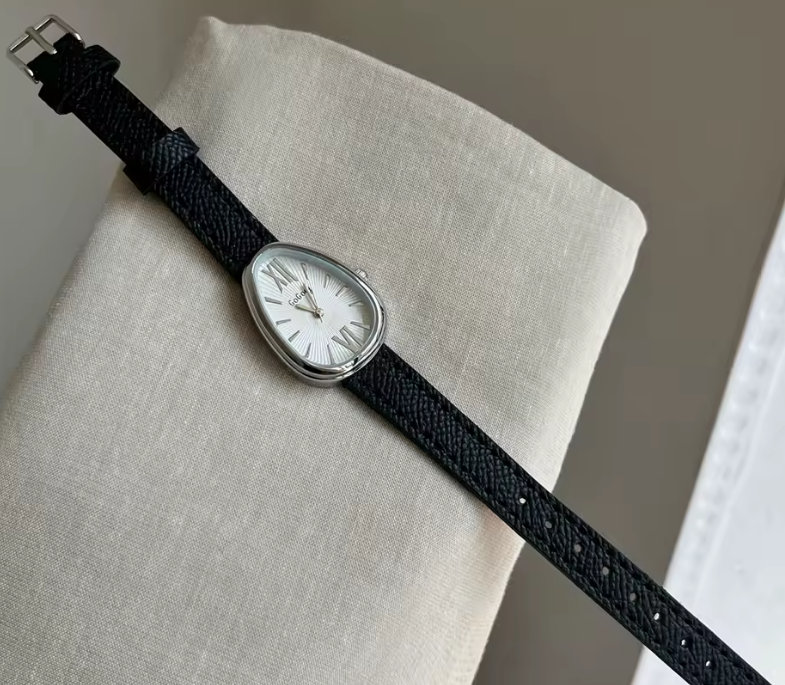 Watch with a black strap on a light gray surface